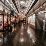 A bustling interior view of Chelsea Market showcasing diverse food stalls and crowds of people.