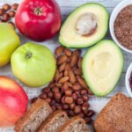 A colorful array of high-fiber plant-based foods including fruits, vegetables, legumes, nuts, seeds, and whole grains, promoting healthy digestion.