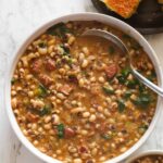 A comforting bowl of Southern Black-Eyed Peas with cornbread, garnished with green onions