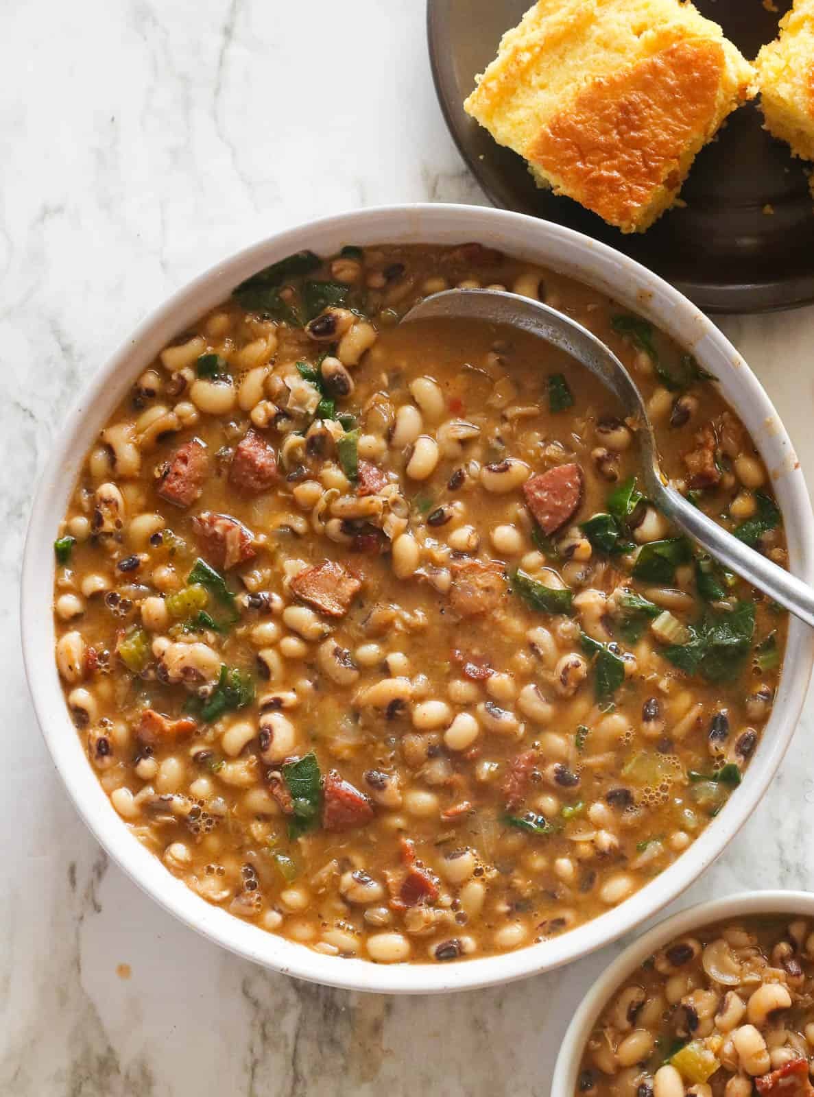 A comforting bowl of Southern Black-Eyed Peas with cornbread, garnished with green onions