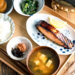 A Japanese meal set with shio koji salmon, miso soup, rice, and side dishes.