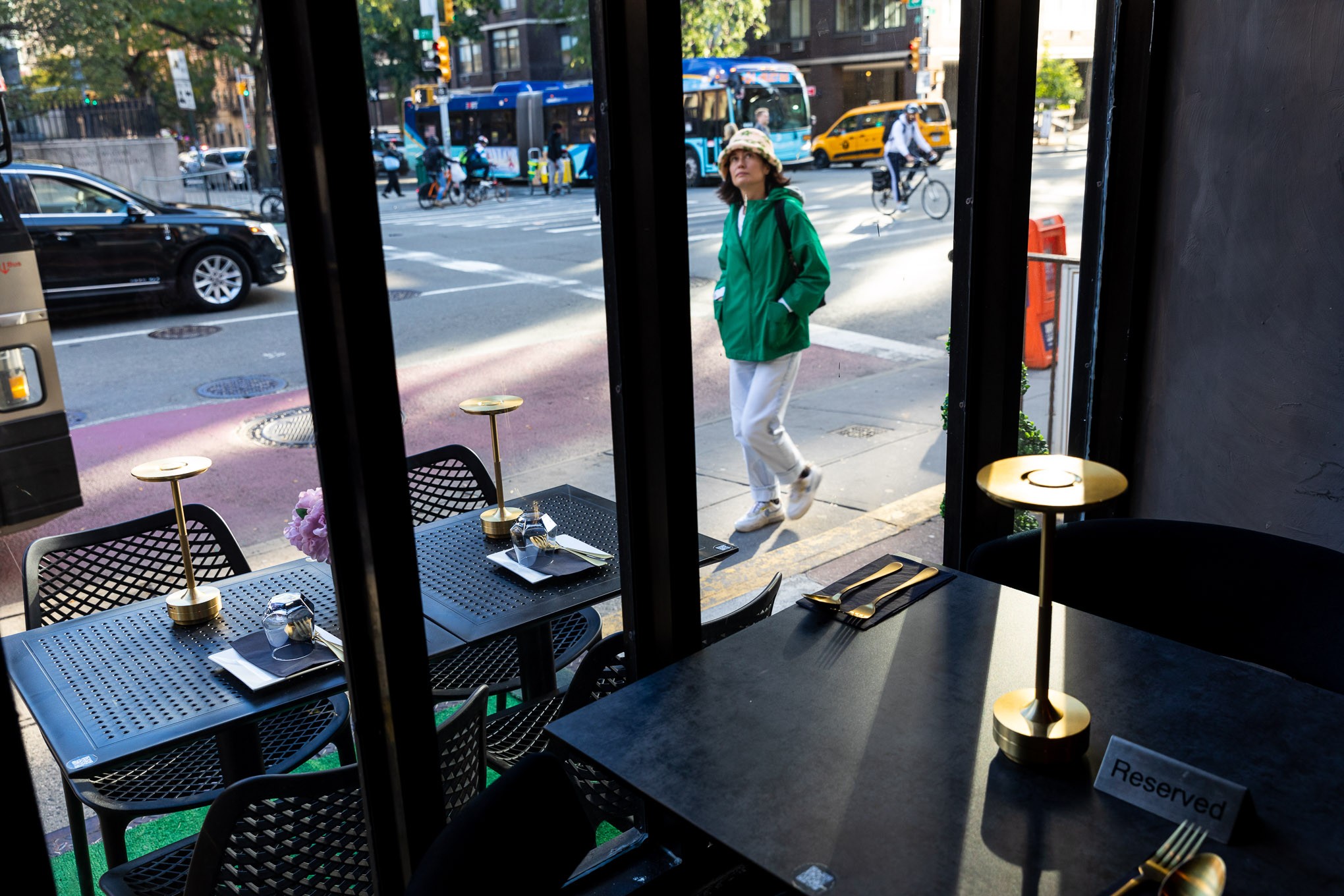 A pedestrian glances up at the "Thai Food Near Me" restaurant sign in New York City.