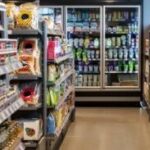 A person is grocery shopping in a supermarket aisle, selecting fresh produce.