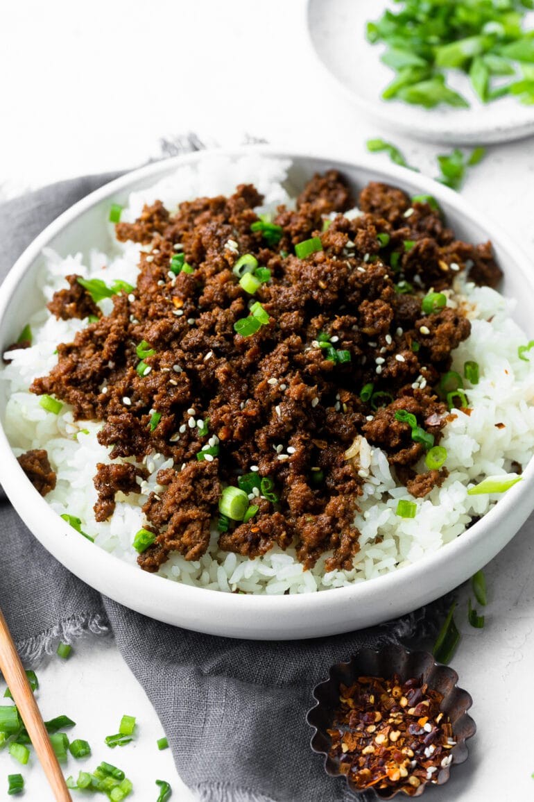 a photo of a bowl of steamed white rice topped with korean ground beef and sliced green onions