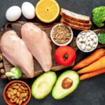 A range of foods high in Niacin (or Vitamin B3) including legumes, nuts, seeds, carrots, chicken, avocado, eggs, grains, broccoli