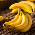 A selection of foods that help with nausea, including toast, bananas, and ginger tea, arranged on a kitchen counter.