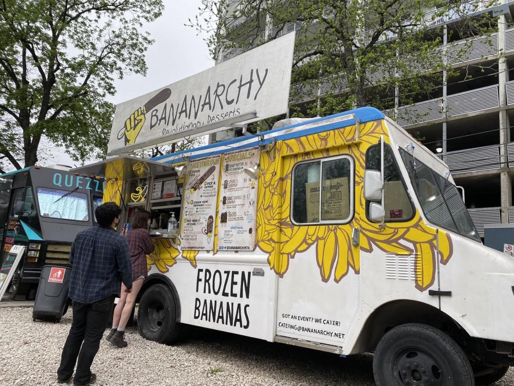 A vibrant crowd enjoys desserts from a food truck, capturing the fun atmosphere of dessert trucks catering.