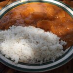 A vibrant dish of rice with pumpkin cooked in g-nut sauce, showcasing the sweetness and nutty flavors of Ugandan cuisine