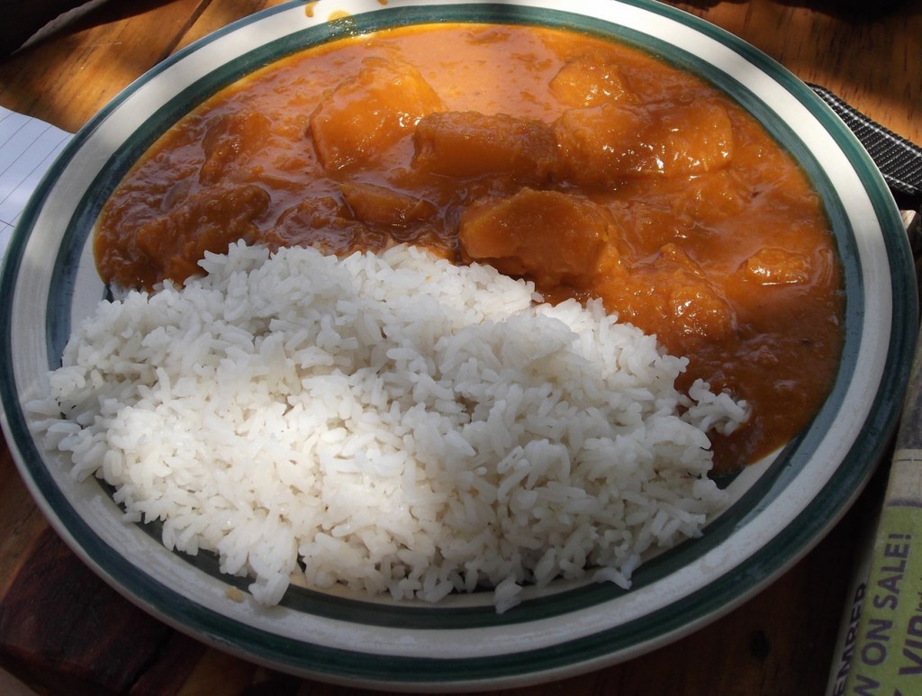 A vibrant dish of rice with pumpkin cooked in g-nut sauce, showcasing the sweetness and nutty flavors of Ugandan cuisine