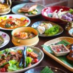 A vibrant table spread of various Thai dishes