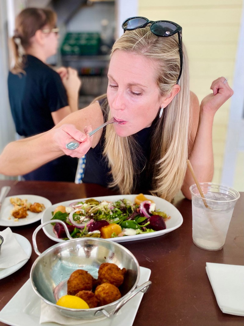 An array of colorful conch fritters, bourbon and ham skewers, and mason jar s’mores, representing diverse Charlotte food offerings.