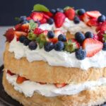 Angel food cake on a black plate, showcasing its light and airy texture.