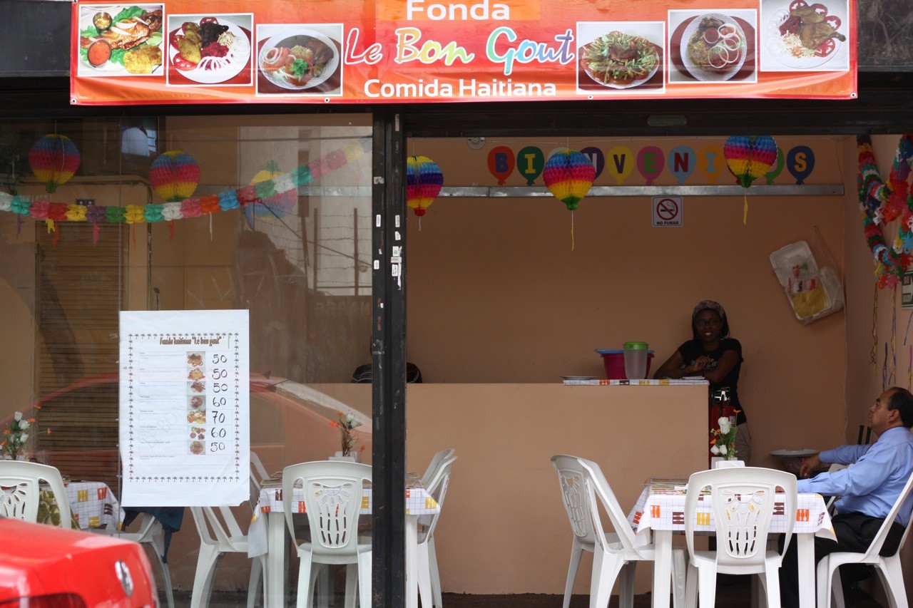 Assortment of Haitian dishes featuring rice, fried plantains, and meats