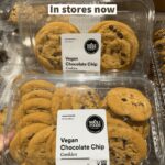 Assortment of vegan baked goods, possibly including muffins and cookies, on a Whole Foods shelf, indicating the product range being discussed.