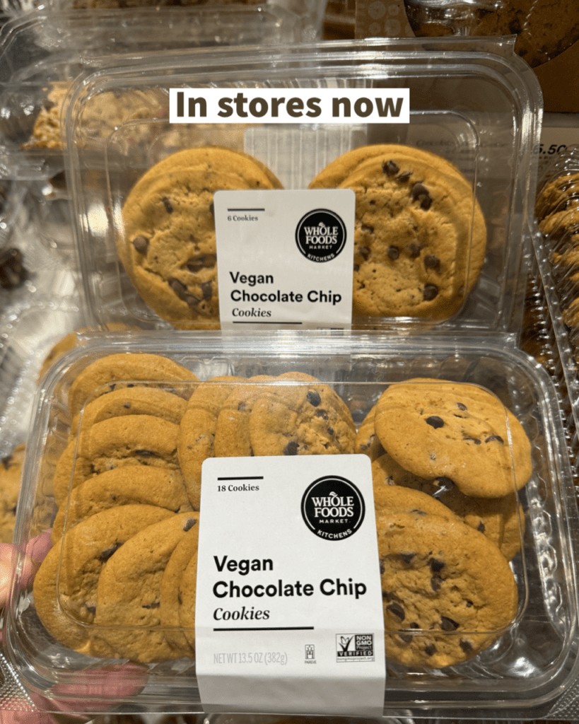 Assortment of vegan baked goods, possibly including muffins and cookies, on a Whole Foods shelf, indicating the product range being discussed.