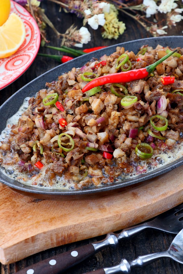 Authentic Filipino Pork Sisig Recipe served sizzling hot on a metal plate.