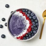 Bowl of acai smoothie with fresh berries and granola, showcasing a healthy breakfast option for kidney health.