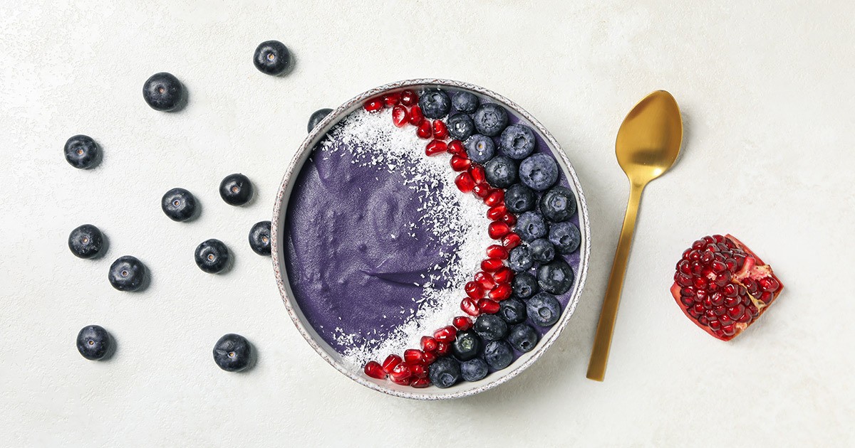 Bowl of açai smoothie with fresh berries and granola topping