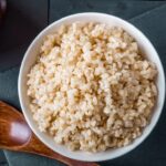 Bowl of brown rice with a wooden spoon highlighting its nutritional food value