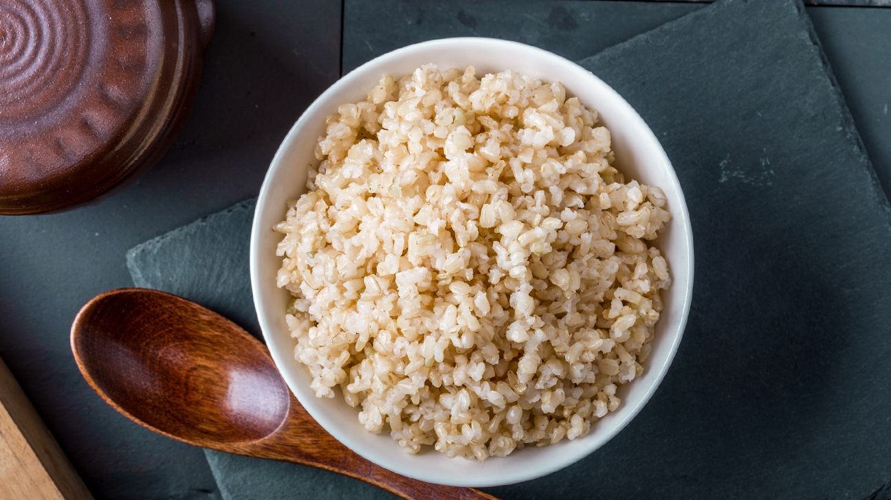 Bowl of brown rice with a wooden spoon highlighting its nutritional food value