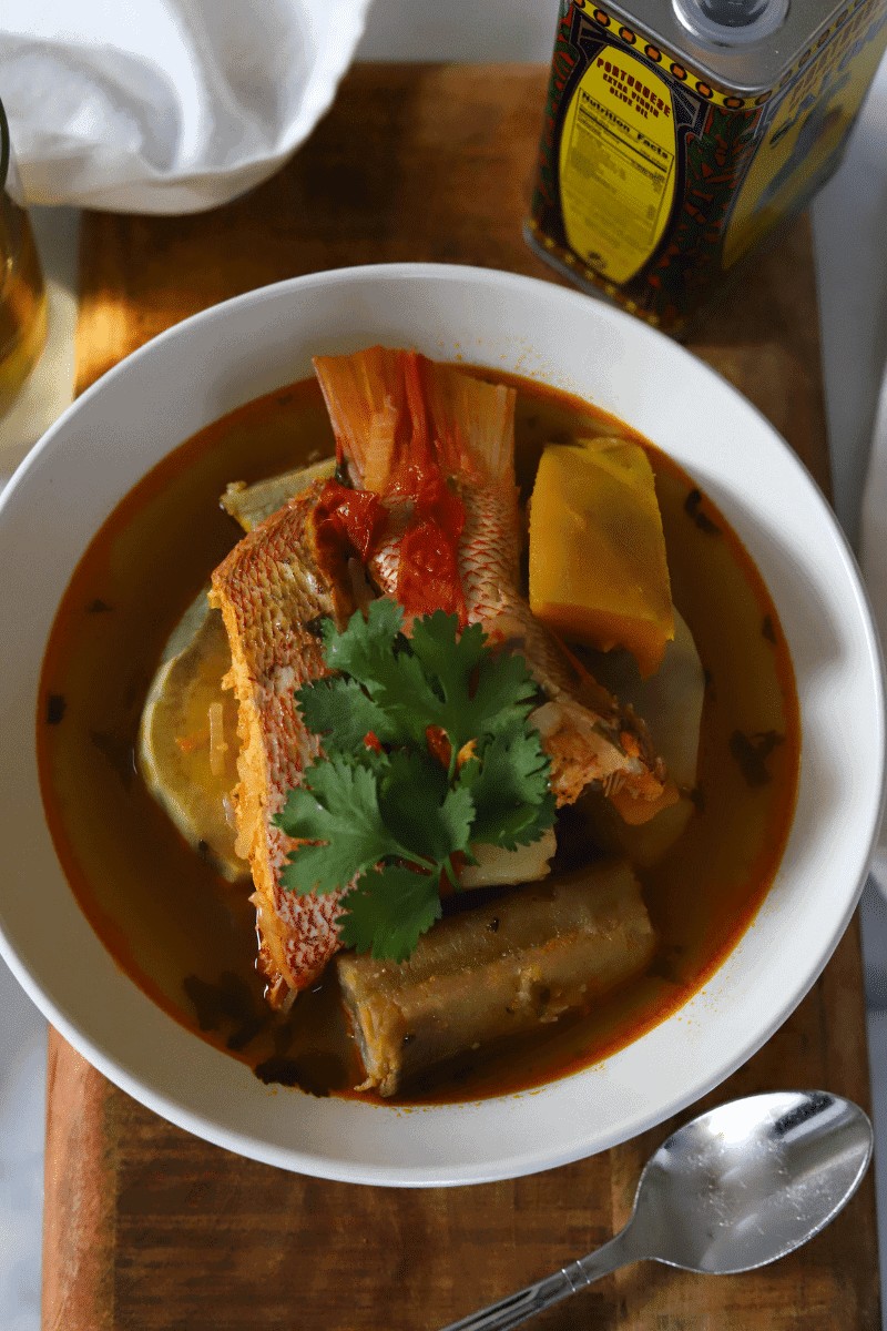 Bowl of caldo de peixe, a traditional Cape Verde food fish stew with red snapper, squash, potatoes, banana and cilantro