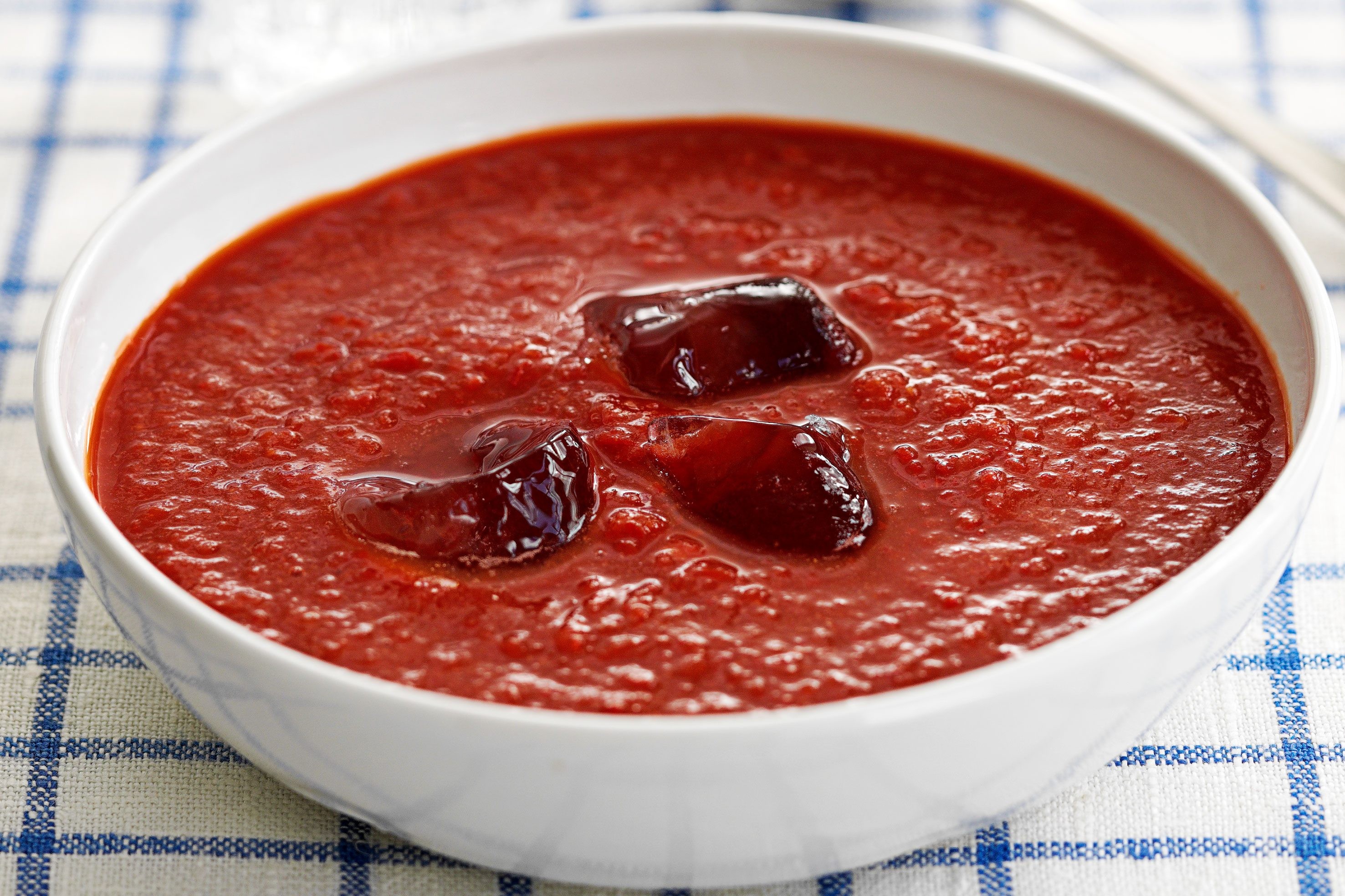 Bowl of chilled gazpacho soup, garnished with fresh vegetables