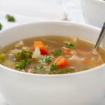 Bowl of hearty vegetable soup with vibrant green vegetables