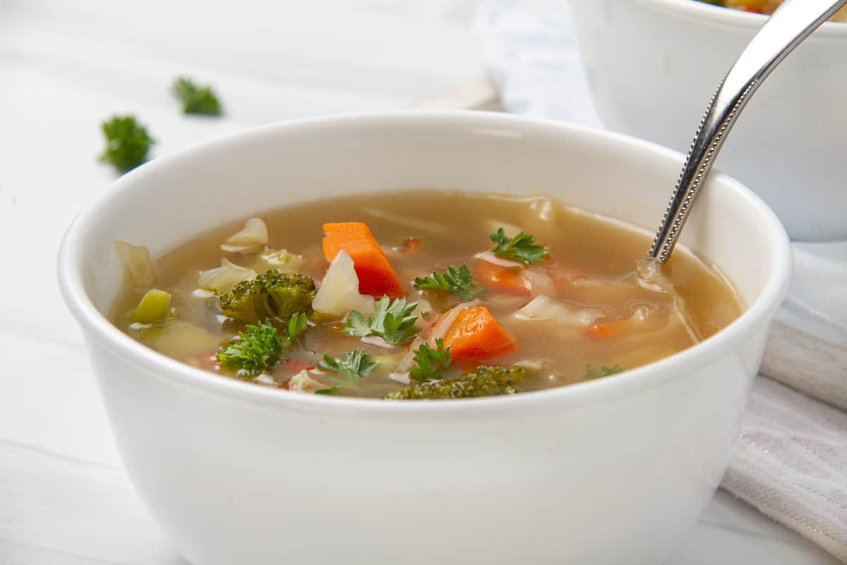 Bowl of hearty vegetable soup with vibrant green vegetables