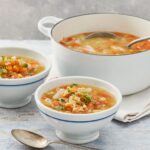 Bowl of lentil soup with visible lentils, carrots, and parsley, suggesting a healthy and simple lunch option.