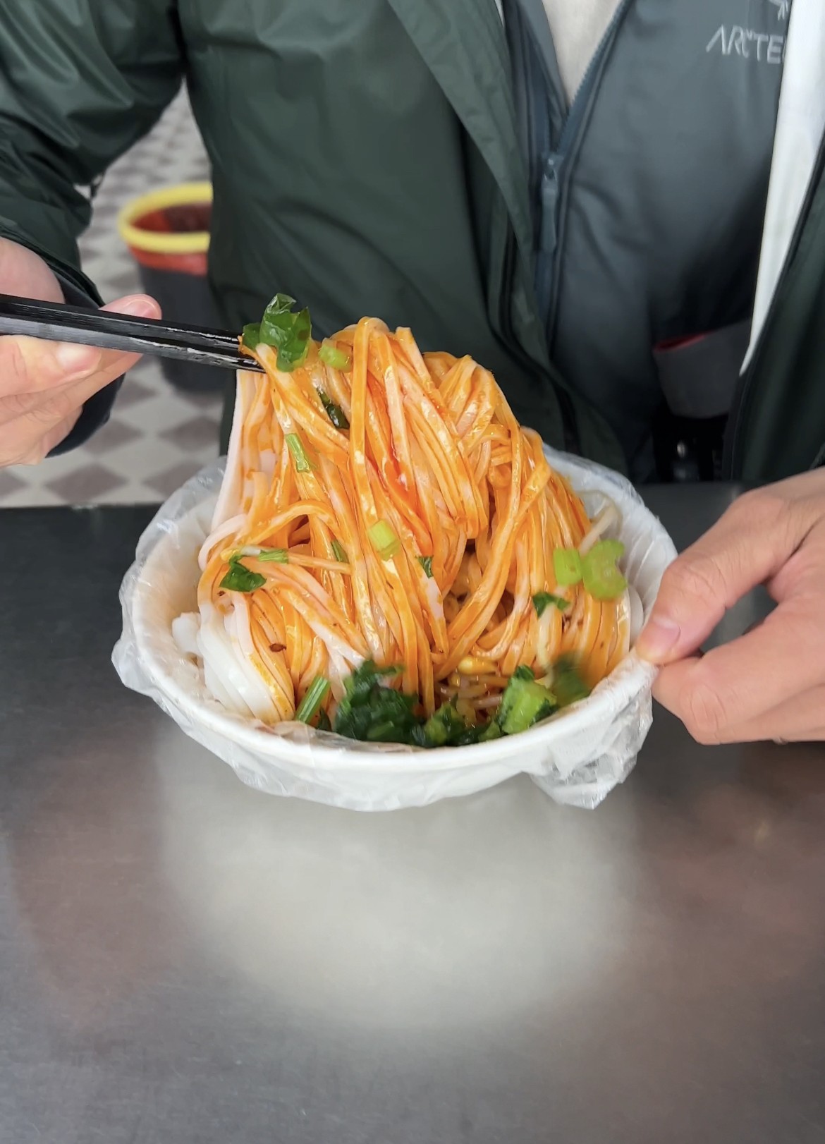 Bowl of Liang Pi cold noodles, a classic Xian food, showcasing the noodles and vegetable toppings.