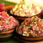 Bowl of poke with raw fish, avocado, seaweed, and sesame seeds