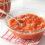 Bowl of rosy applesauce with a spoon, showcasing a soft and easily digestible fruit option.