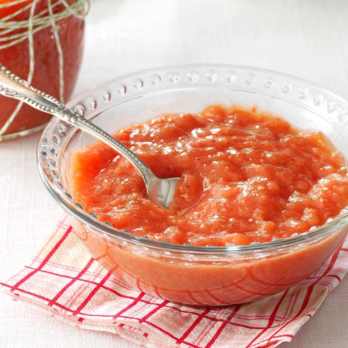 Bowl of rosy applesauce with a spoon, showcasing a soft and easily digestible fruit option.