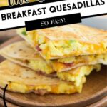 Breakfast quesadilla filled with eggs, bacon, cheese, and green peppers on a plate.