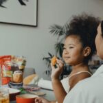 Child happily holding an orange, representing access to healthy food in Baton Rouge, LA.