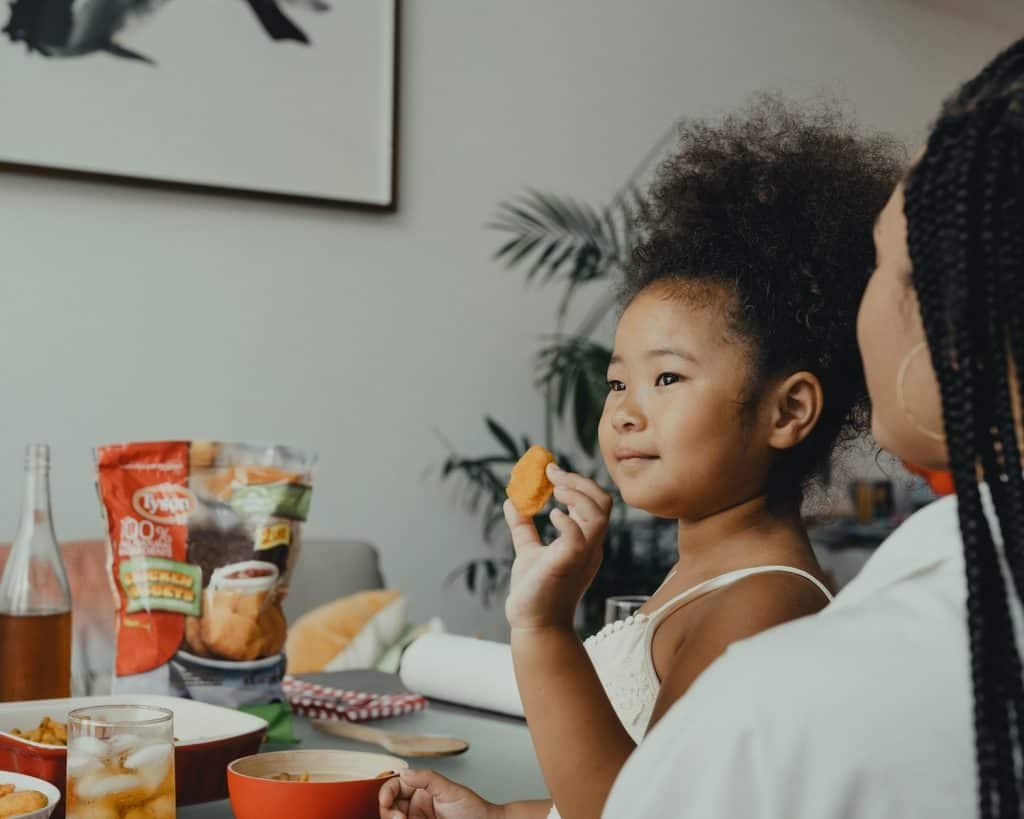 Child happily holding an orange, representing access to healthy food in Baton Rouge, LA.