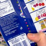 Close-up of a candy ingredient label highlighting Red Dye 40, Blue 2, and Yellow 5, common artificial food colorings in processed foods.