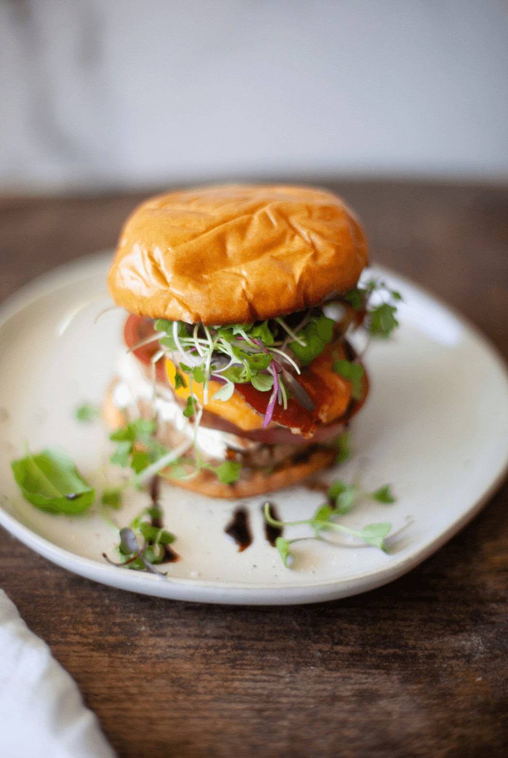 Close-up of a peach and goat cheese turkey burger on a plate, highlighting the juicy peach and melted goat cheese