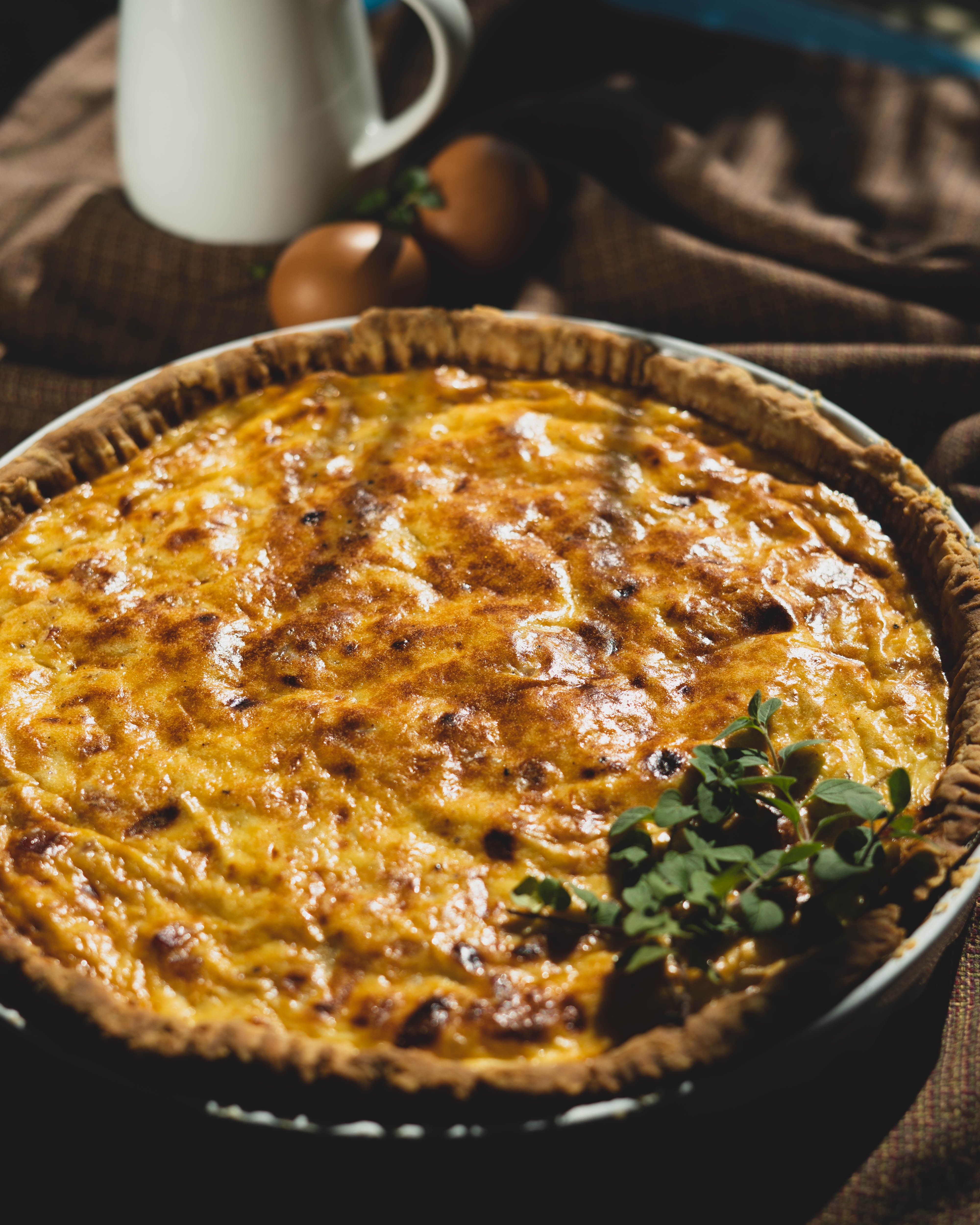 Close-up of a slice of Quiche Lorraine with visible layers of crust, filling, and bacon, showcasing its texture and ingredients.