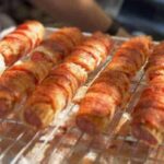 Close-up of bacon-wrapped shotgun shells, showcasing the crispy bacon and cheesy filling.