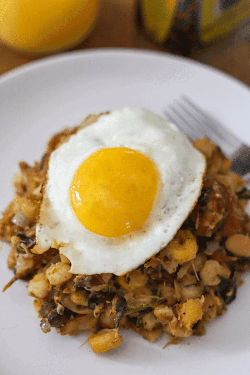 Close-up of cachupa refogada, a popular Cape Verde food breakfast, topped with a fried egg