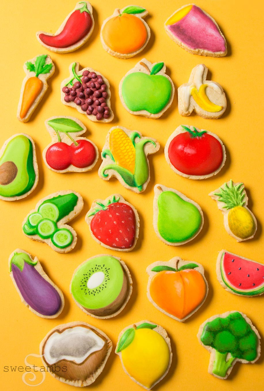 Close up of fruit and vegetable emoji cookies including corn, broccoli, coconut, kiwi, carrot and strawberry