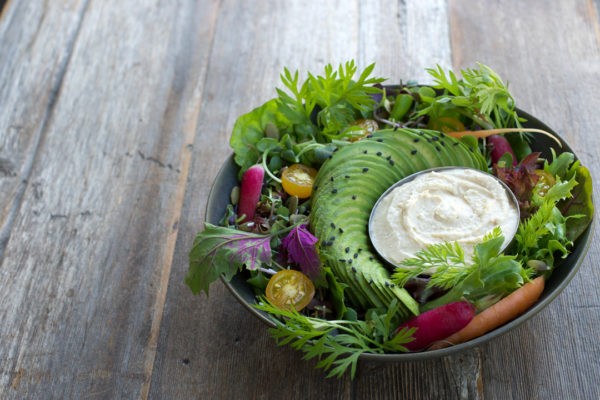 Close-up shot of a vibrant salad in a white bowl, showcasing fresh ingredients and backlighting