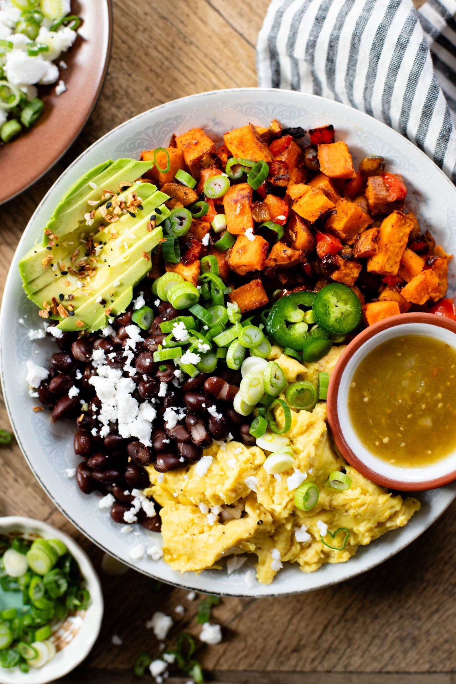 Close-up shot of vibrant vegan breakfast bowls filled with roasted sweet potatoes, Just Egg scramble, black beans, and avocado, perfect for those searching for vegan breakfast food near me