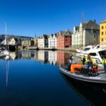 Colorful buildings in Alesund Norway reflecting on waters