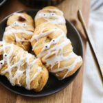 Crescent rolls decorated as mummies with candy eyes peeking out, perfect for a Halloween treat.