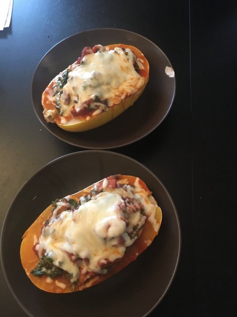 Delicious spaghetti squash boats featuring sausage, kale, mushrooms, and cheese