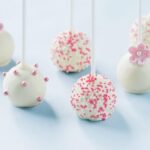 Delicious vanilla cake pops decorated with pink and blue sprinkles, perfect for a gender reveal party.