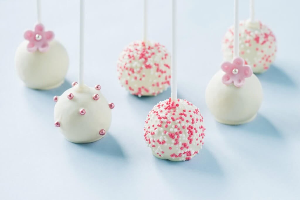 Delicious vanilla cake pops decorated with pink and blue sprinkles, perfect for a gender reveal party.