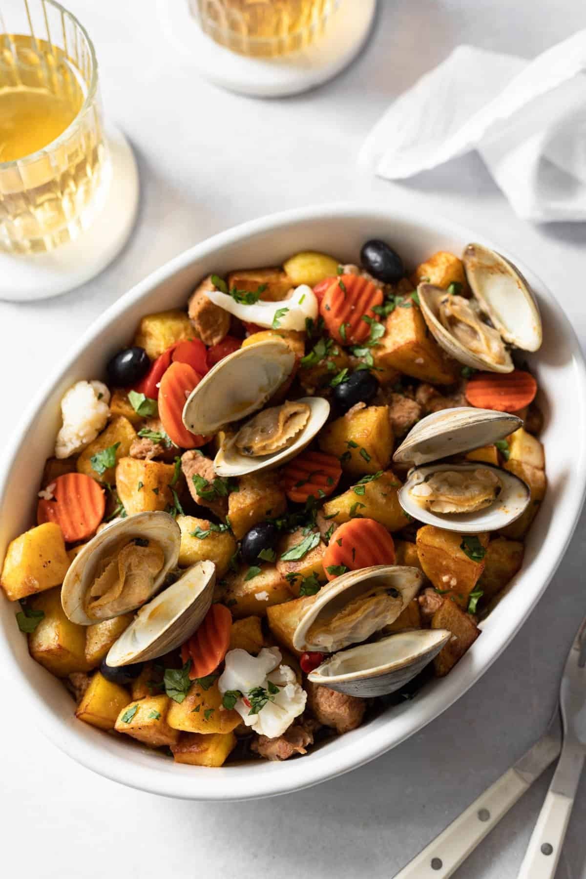 Final presentation of carne de porco à Alentejana, a Cape Verde food pork and clams dish, in a white dish